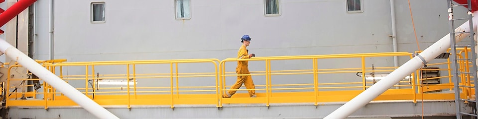 Инженер идет по платформе в Северном море недалеко от Абердина